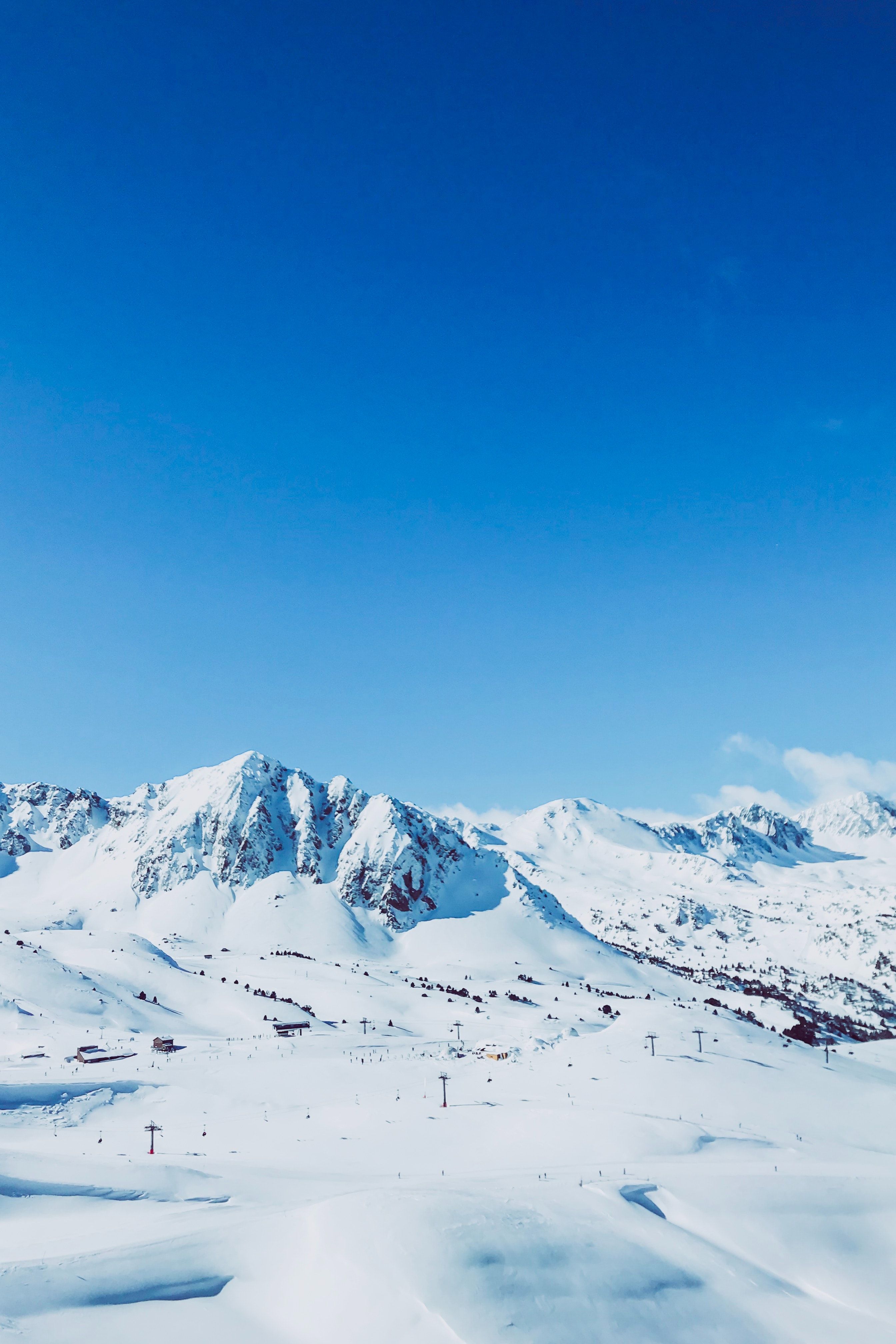 Snødekte tinder under klar blå himmel