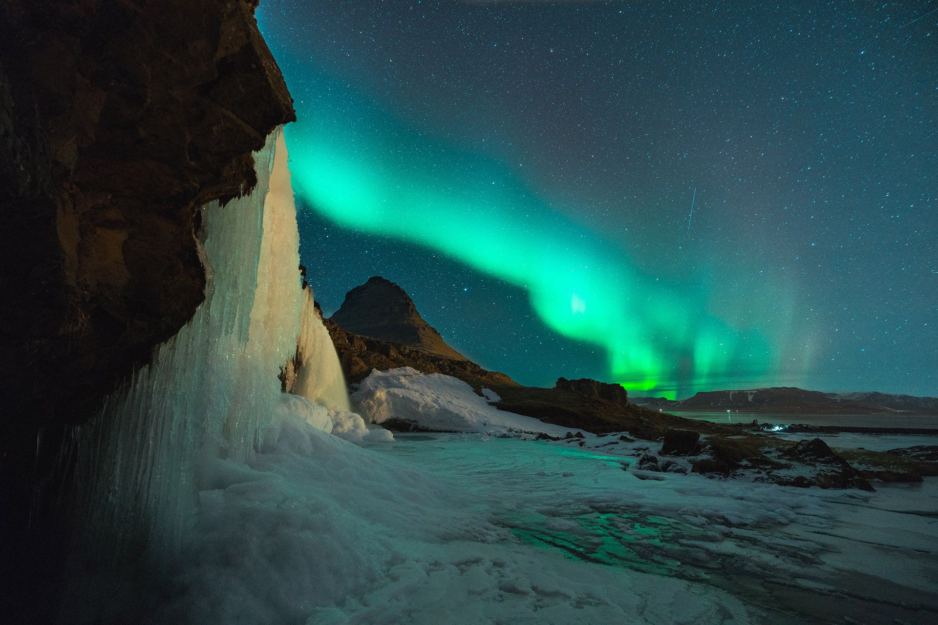 Nordlys over snødekte fjell en vinternatt